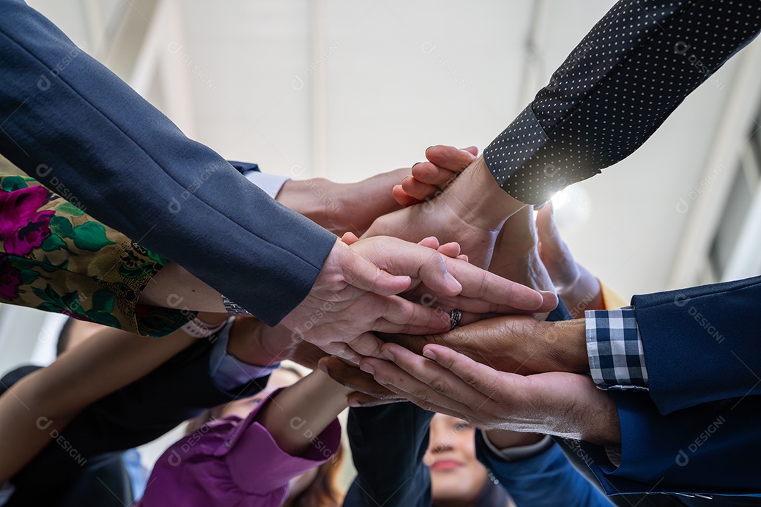 Conceito de equipe, trabalho em equipe e unidade. Equipe diversificada juntando as mãos. Grupo de diversos empresários.