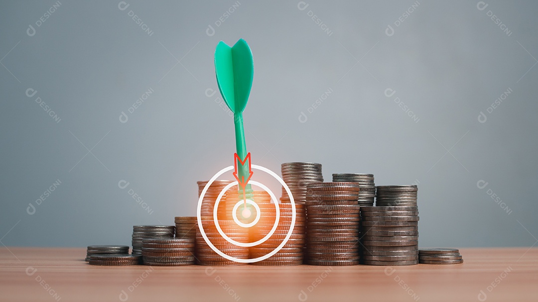 A seta verde atinge o alvo no centro de uma fileira de moedas no chão de madeira. Conceitos de finanças, poupança e investimento.