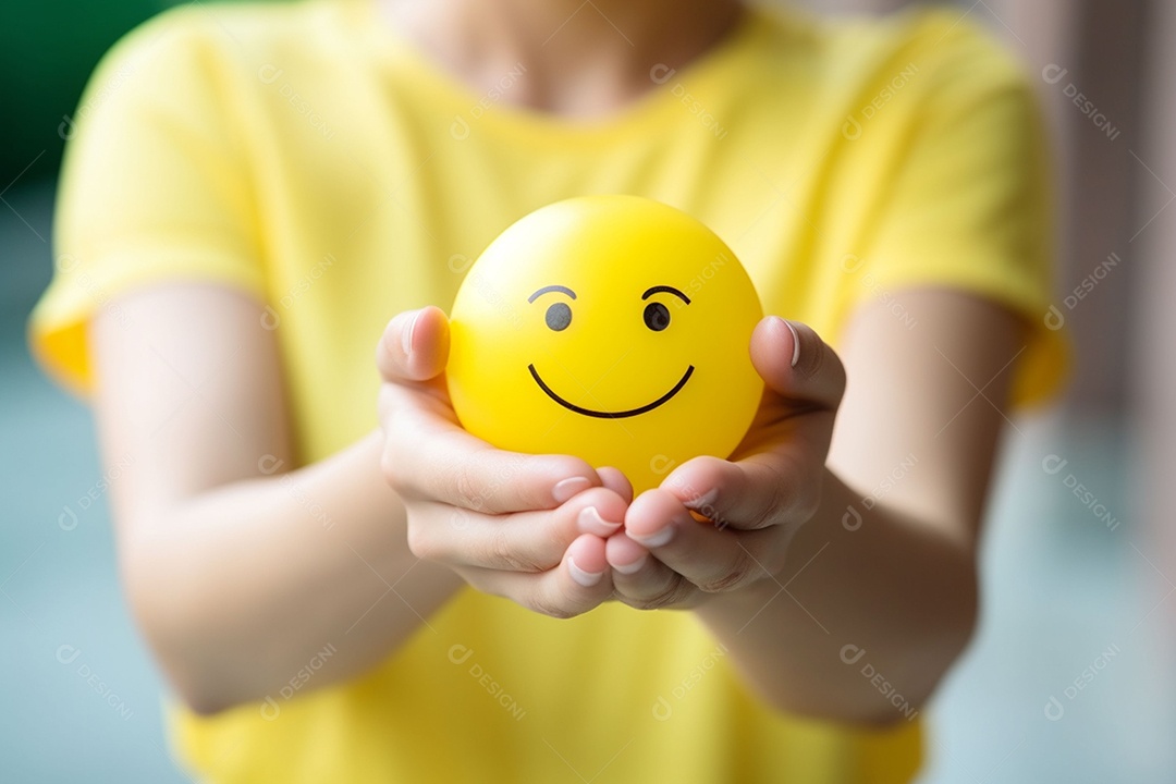 Mão de uma mulher segurando a posição da esfera emoji de sorriso feliz