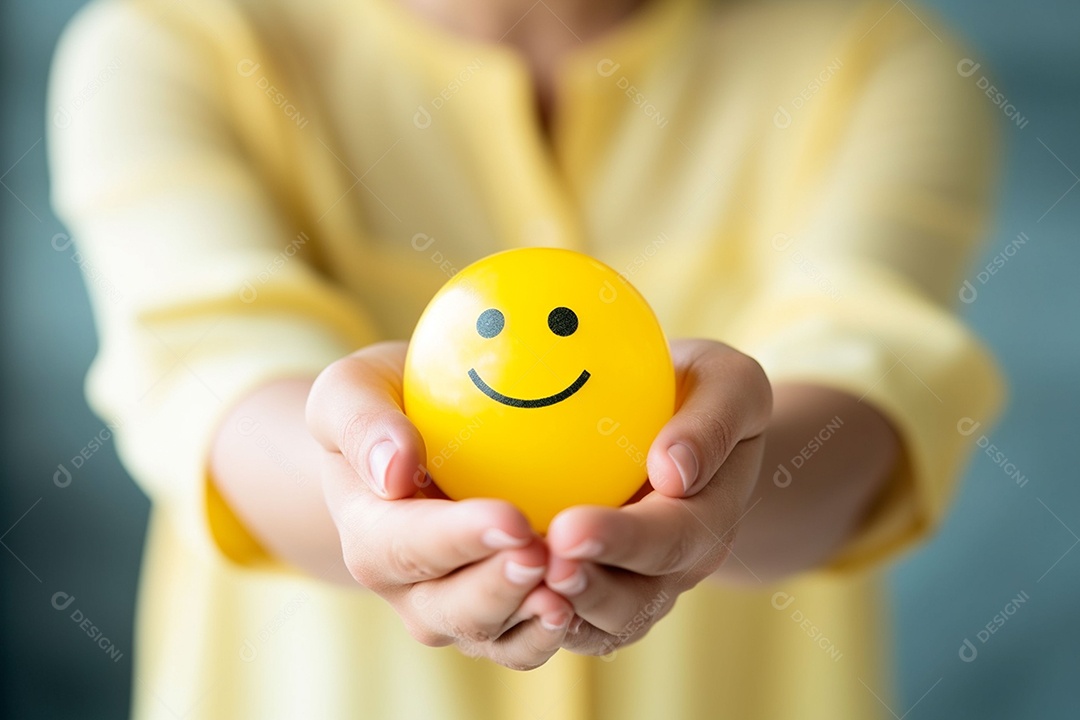 Mão de uma mulher segurando a posição da esfera emoji de sorriso feliz