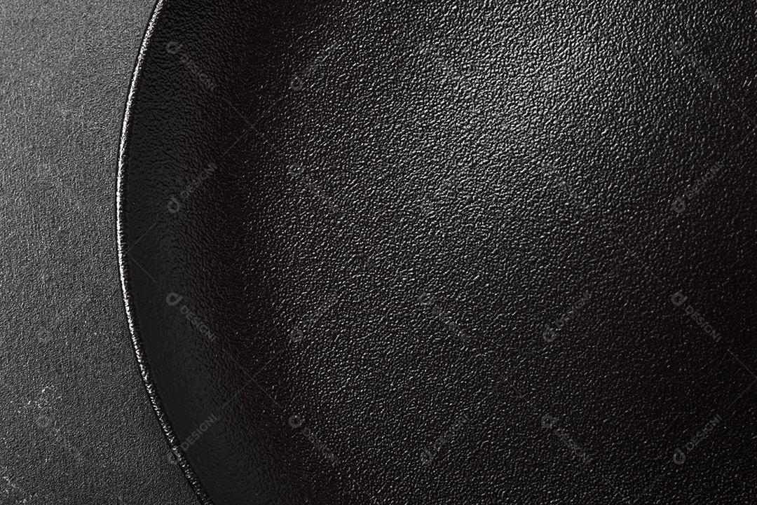 Placa cerâmica preta vazia sobre um fundo escuro de concreto. Preparando a mesa para um jantar em família