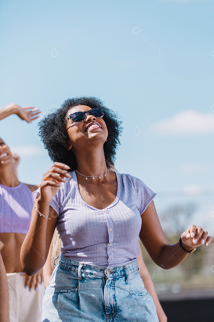 Mulher jovem e bonita sorrindo no meio da multidão. Foto vertical.