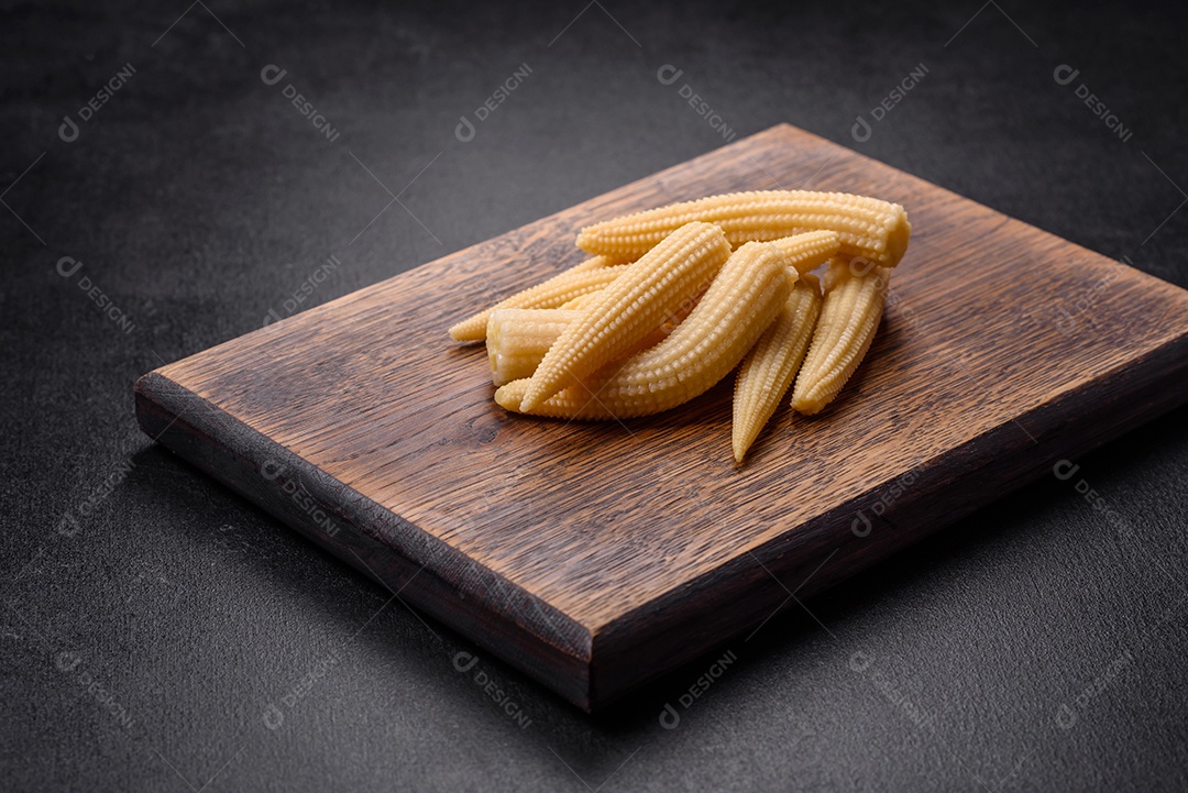 Um monte de pequeno milho enlatado branco sobre um fundo escuro de concreto. Cozinhar refeições em casa