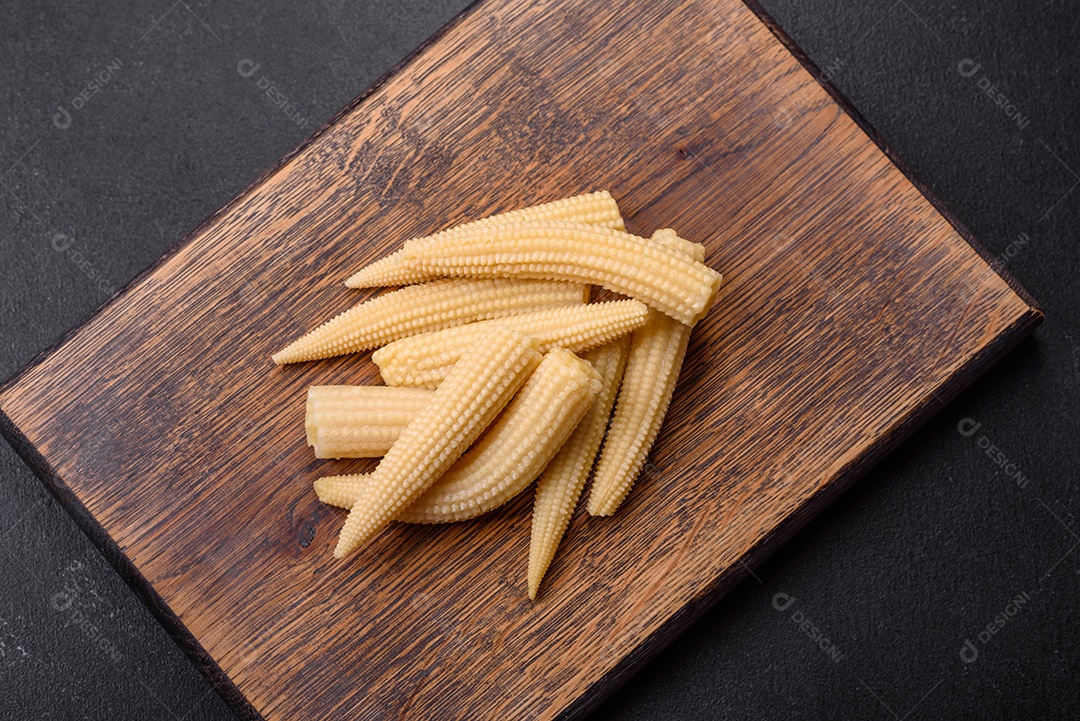 Um monte de pequeno milho enlatado branco sobre um fundo escuro de concreto. Cozinhar refeições em casa