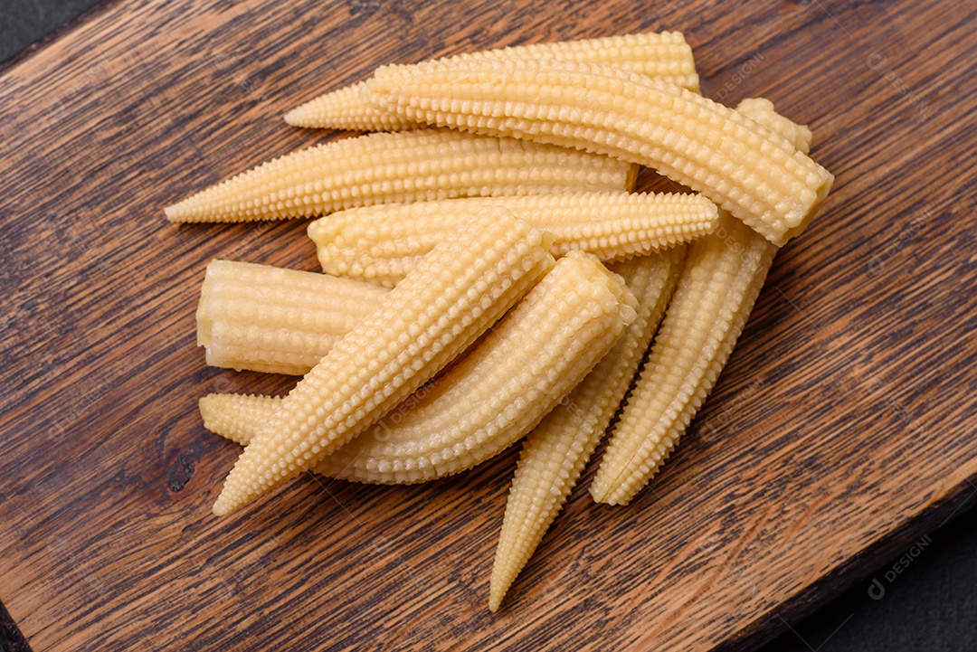 Um monte de pequeno milho enlatado branco sobre um fundo escuro de concreto. Cozinhar refeições em casa