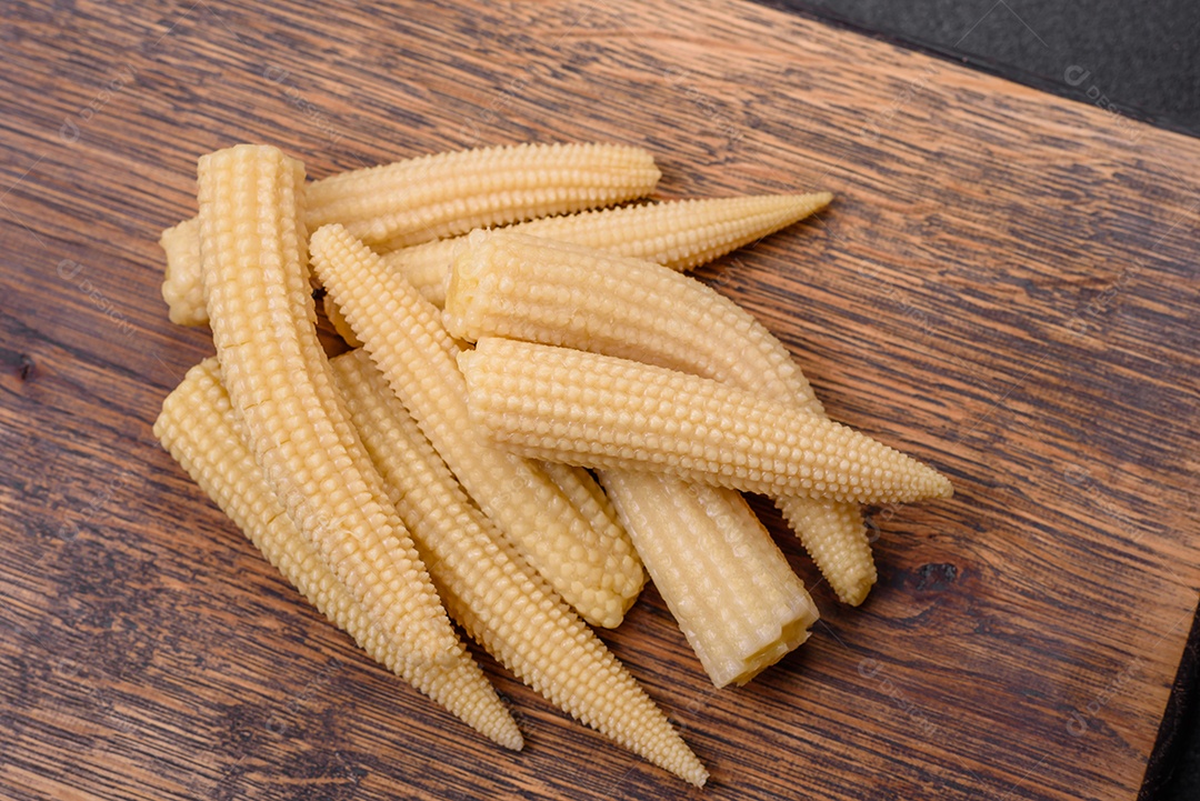 Um monte de pequeno milho enlatado branco sobre um fundo escuro de concreto. Cozinhar refeições em casa