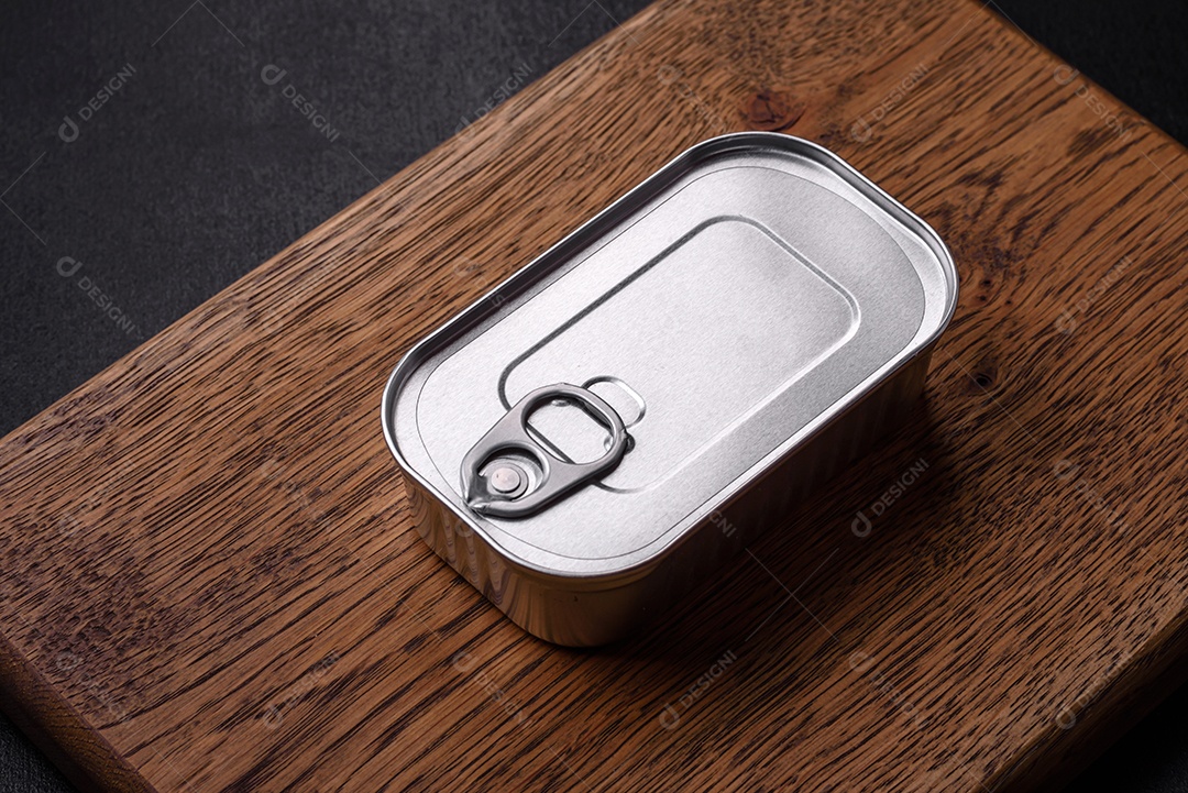 Lata retangular de estanho ou alumínio de alimentos enlatados com uma chave sobre um fundo escuro de concreto