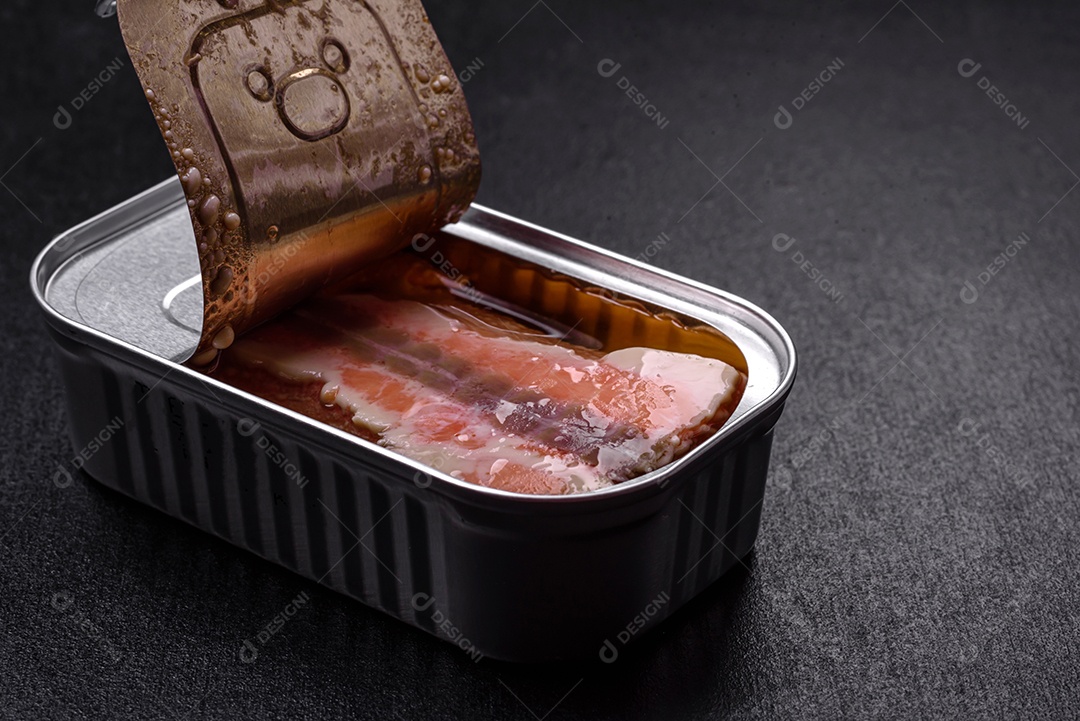 Lata retangular de estanho ou alumínio de salmão enlatado com chave sobre fundo escuro de concreto