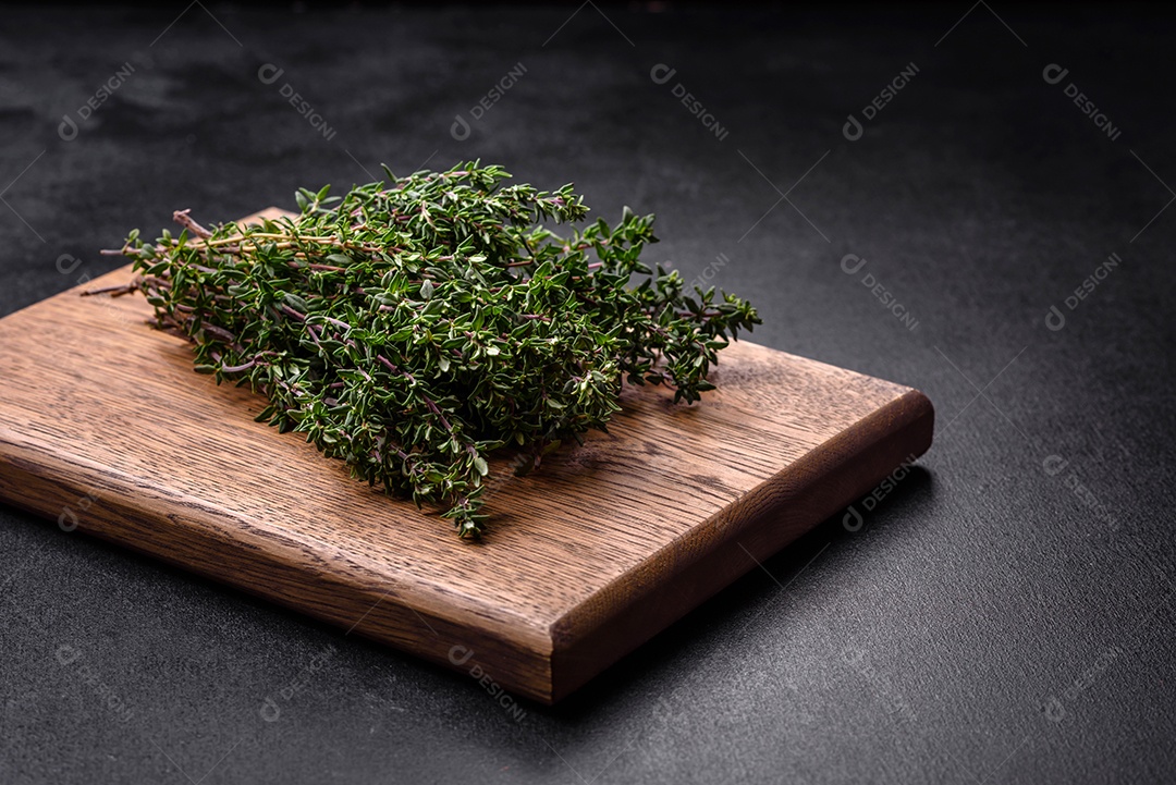 Bando de tomilho fresco colhido em um fundo escuro de concreto. Especiarias e ervas para cozinhar carne