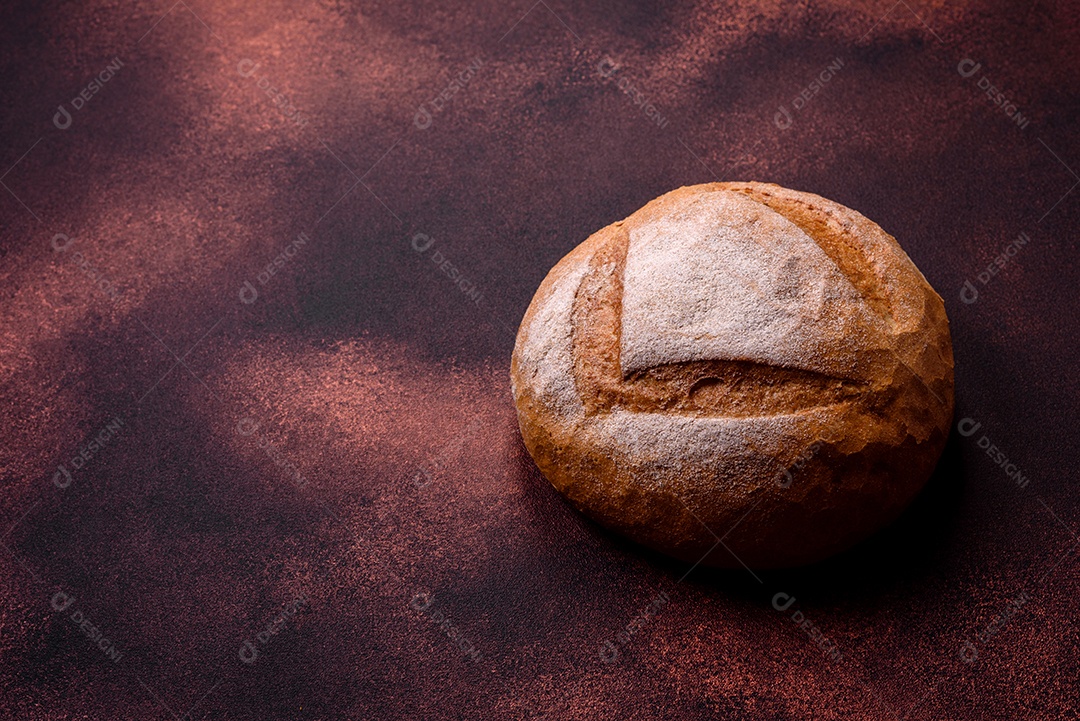 Lindo e delicioso pão branco redondo recém-assado sobre um fundo escuro de concreto