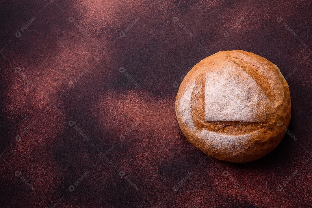 Lindo e delicioso pão branco redondo recém-assado sobre um fundo escuro de concreto