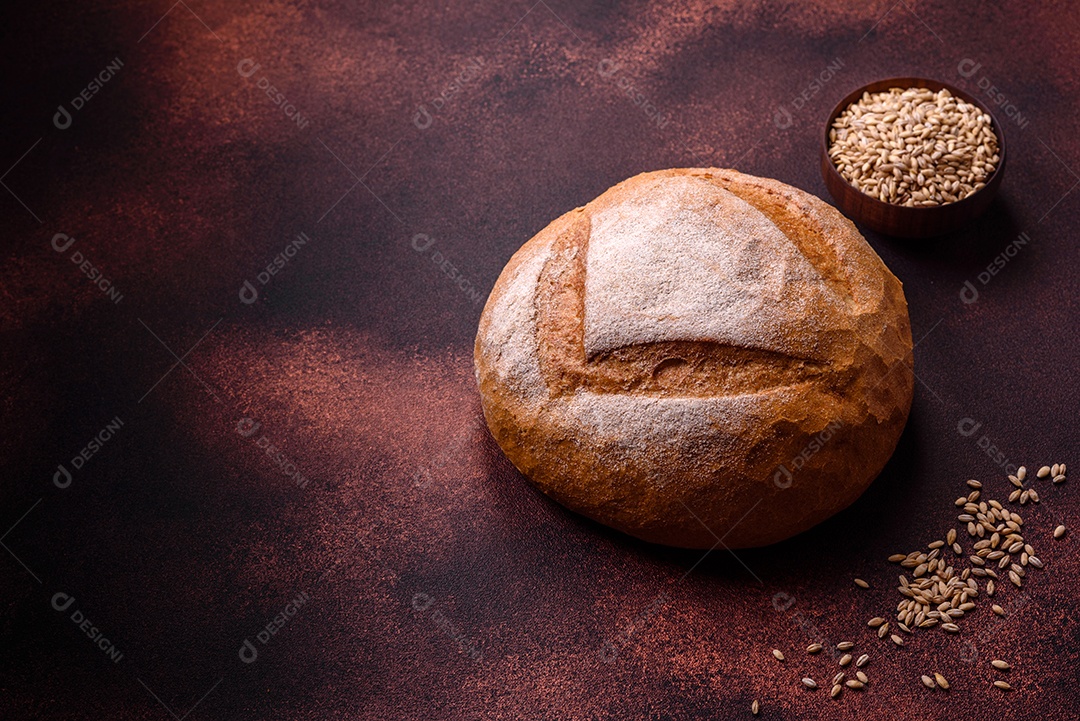 Lindo e delicioso pão branco redondo recém-assado sobre um fundo escuro de concreto