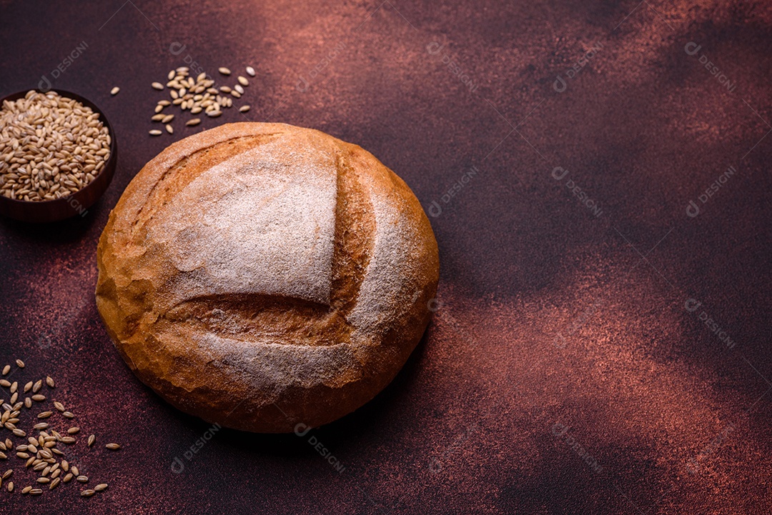 Lindo e delicioso pão branco redondo recém-assado sobre um fundo escuro de concreto