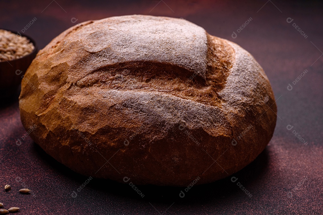 Lindo e delicioso pão branco redondo recém-assado sobre um fundo escuro de concreto
