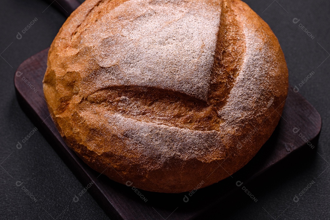 Lindo e delicioso pão branco redondo recém-assado sobre um fundo escuro de concreto