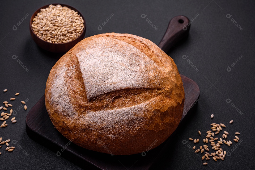 Lindo e delicioso pão branco redondo recém-assado sobre um fundo escuro de concreto