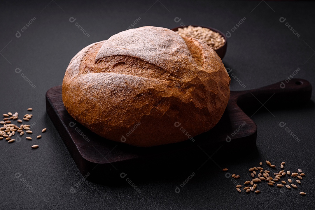 Lindo e delicioso pão branco redondo recém-assado sobre um fundo escuro de concreto