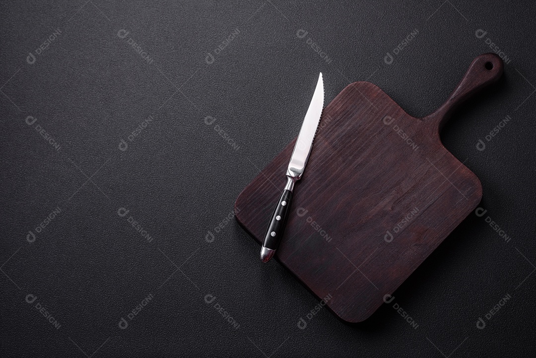 Tábua de corte de madeira marrom vazia em fundo escuro de concreto. Cozinhando em casa