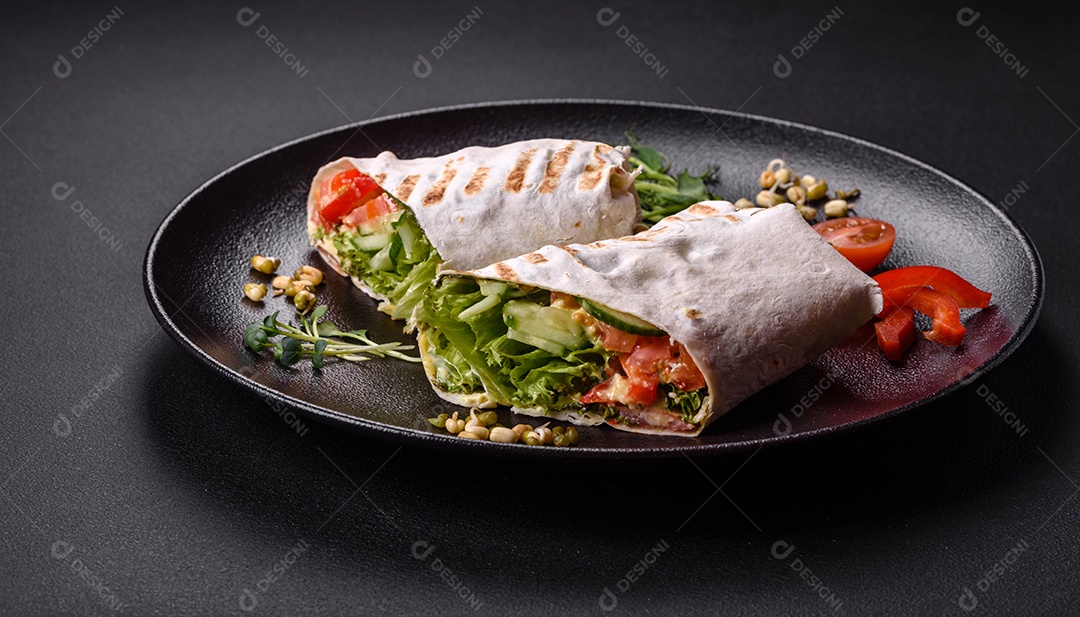 Delicioso shawarma fresco com tomate, pimentão, pepino e molhos em um fundo escuro de concreto. Comida rápida