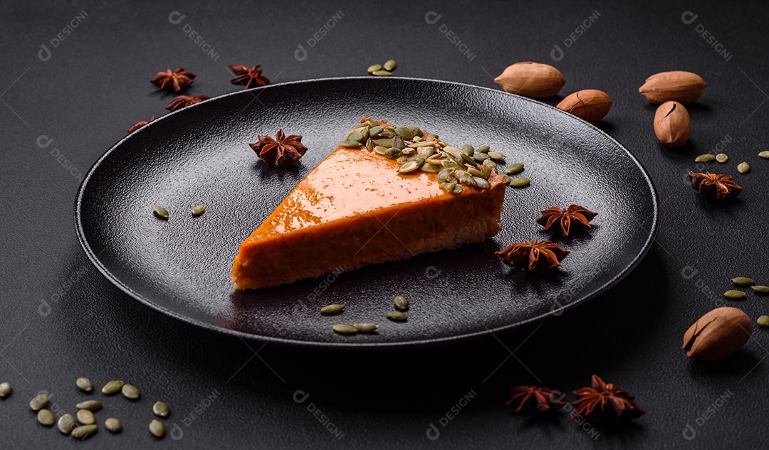 Linda torta de abóbora saborosa com fatias em uma placa de cerâmica preta sobre um fundo escuro de concreto