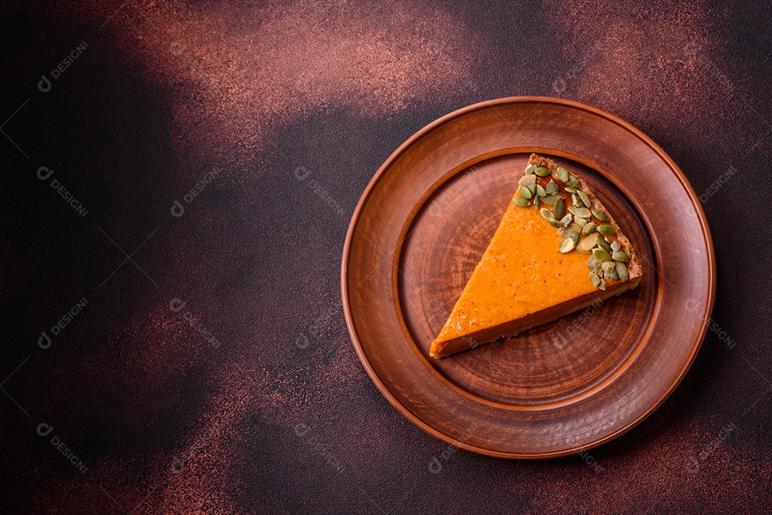 Linda torta de abóbora saborosa com fatias em uma placa de cerâmica preta sobre um fundo escuro de concreto