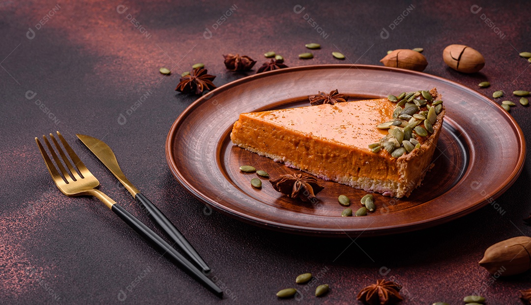 Linda torta de abóbora saborosa com fatias em uma placa de cerâmica preta sobre um fundo escuro de concreto