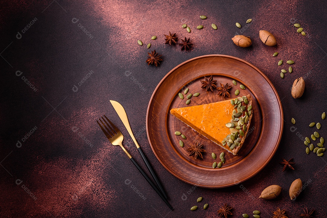 Linda torta de abóbora saborosa com fatias em uma placa de cerâmica preta sobre um fundo escuro de concreto