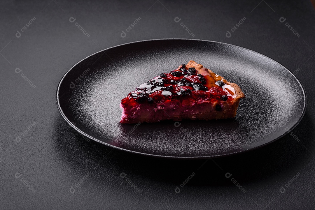 Deliciosa torta fresca com framboesas e outras frutas e queijo em um prato escuro sobre fundo preto