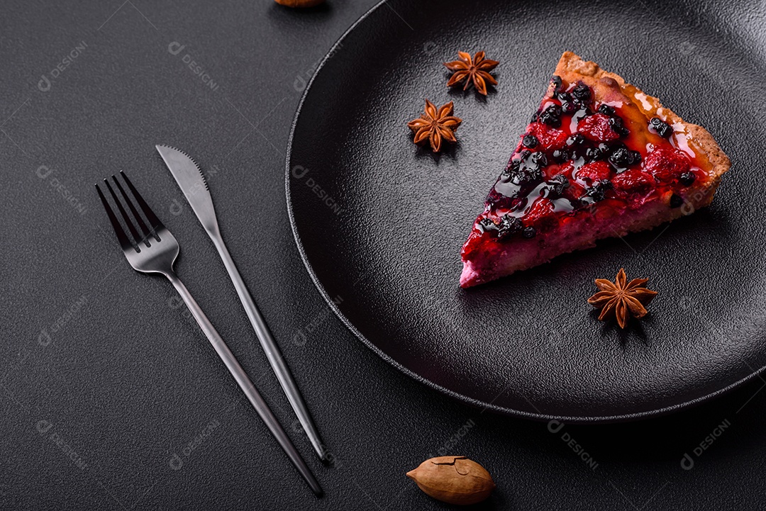 Deliciosa torta fresca com framboesas e outras frutas e queijo em um prato escuro sobre fundo preto