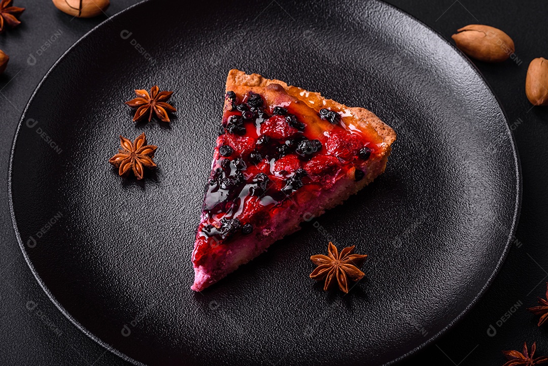 Deliciosa torta fresca com framboesas e outras frutas e queijo em um prato escuro sobre fundo preto