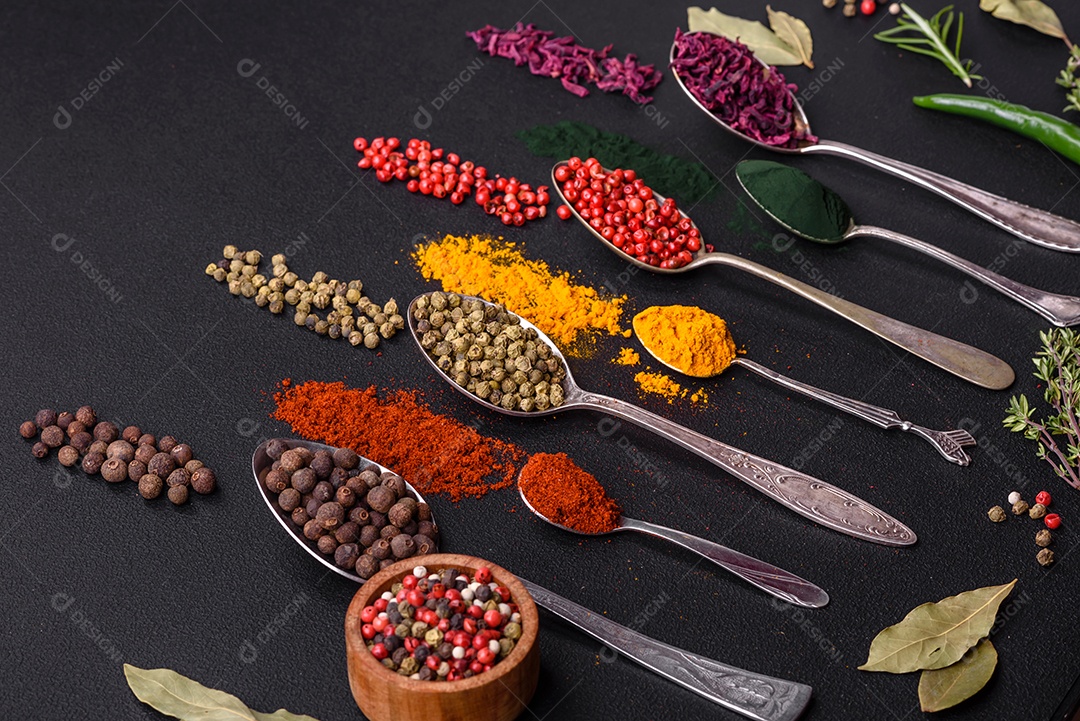Vários tipos de especiarias em colheres de metal páprica, tomate, curry, beterraba, cominho, açafrão