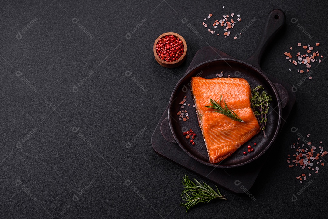 Delicioso filé de peixe vermelho salmão cozido com especiarias e ervas sobre um fundo escuro de concreto