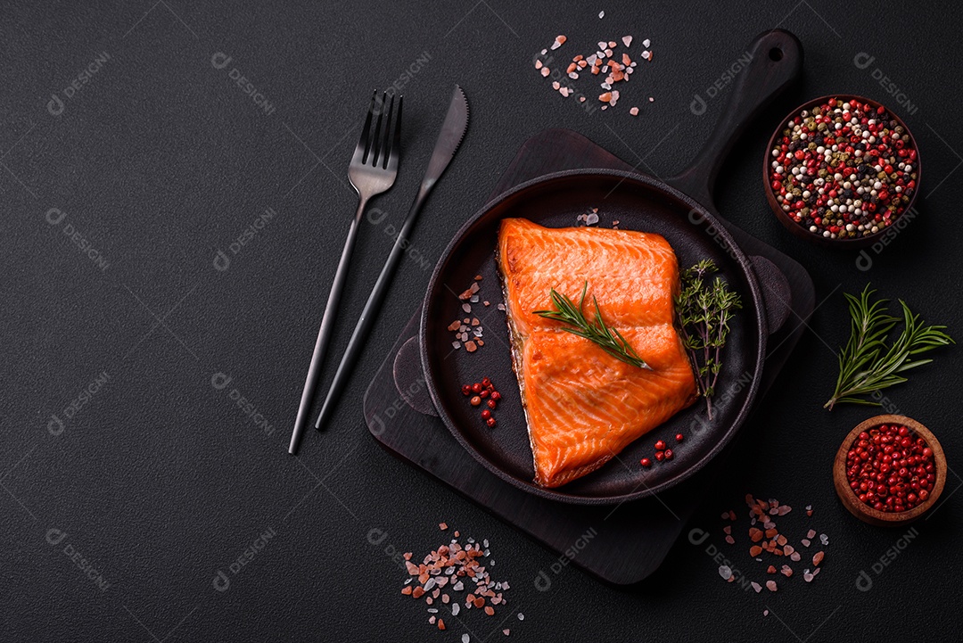 Delicioso filé de peixe vermelho salmão cozido com especiarias e ervas sobre um fundo escuro de concreto