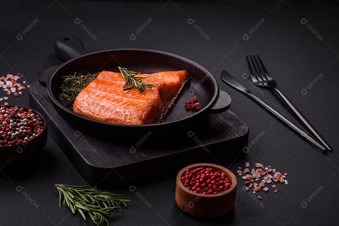 Delicioso filé de peixe vermelho salmão cozido com especiarias e ervas sobre um fundo escuro de concreto