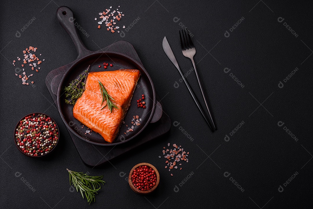 Delicioso filé de peixe vermelho salmão cozido com especiarias e ervas sobre um fundo escuro de concreto