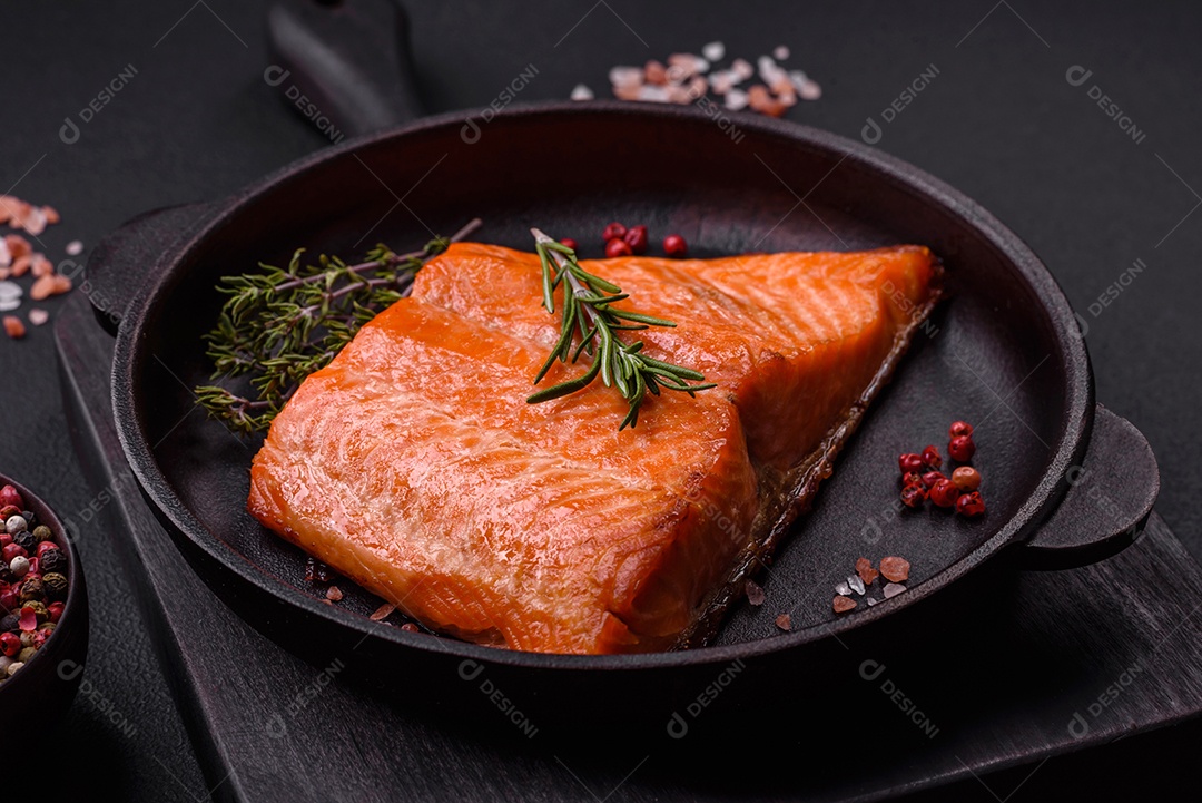 Delicioso filé de peixe vermelho salmão cozido com especiarias e ervas sobre um fundo escuro de concreto