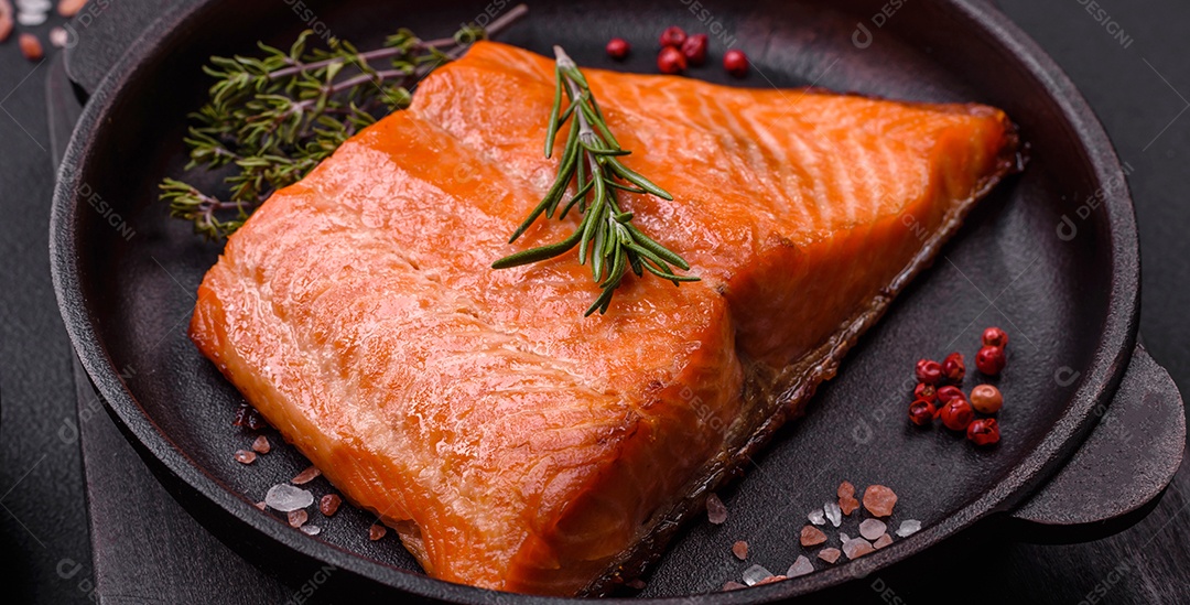 Delicioso filé de peixe vermelho salmão cozido com especiarias e ervas sobre um fundo escuro de concreto