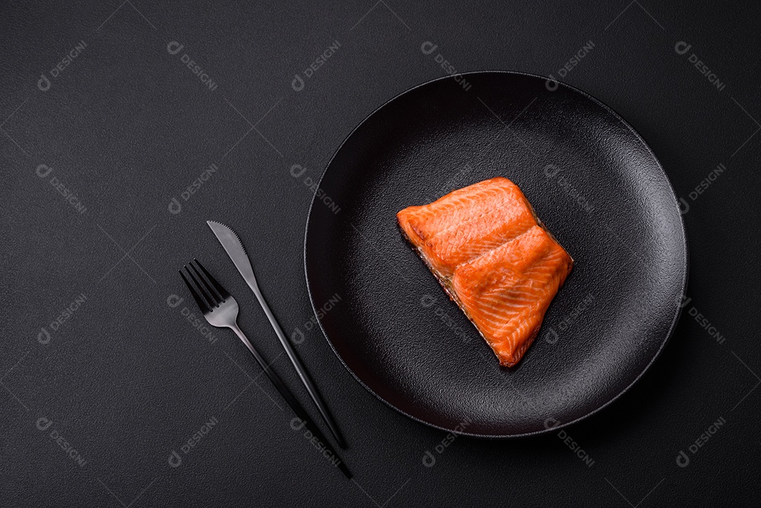 Delicioso filé de peixe vermelho salmão cozido com especiarias e ervas sobre um fundo escuro de concreto