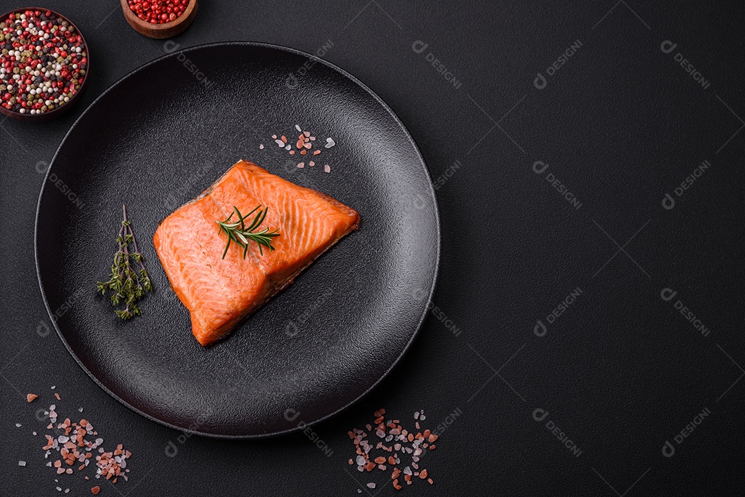 Delicioso filé de peixe vermelho salmão cozido com especiarias e ervas sobre um fundo escuro de concreto