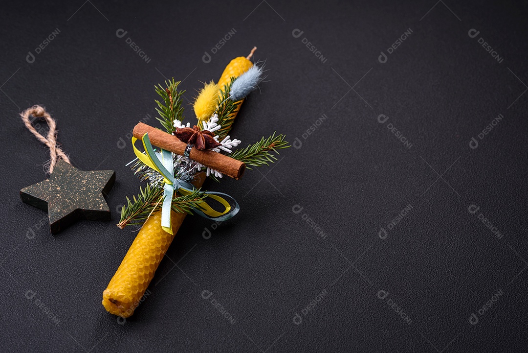 Vela decorada com decorações de Natal em um fundo escuro de concreto. Decoração de casa de férias