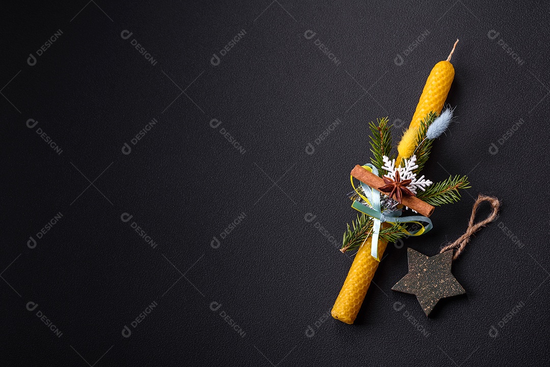 Vela decorada com decorações de Natal em um fundo escuro de concreto. Decoração de casa de férias