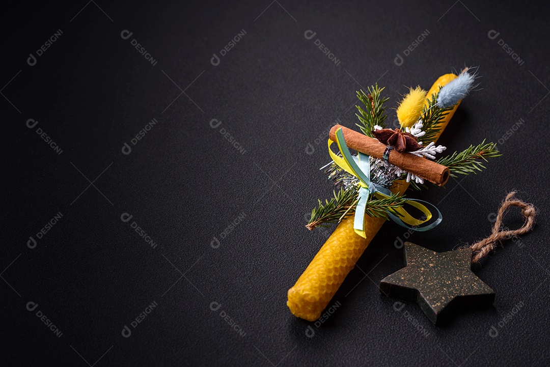 Vela decorada com decorações de Natal em um fundo escuro de concreto. Decoração de casa de férias