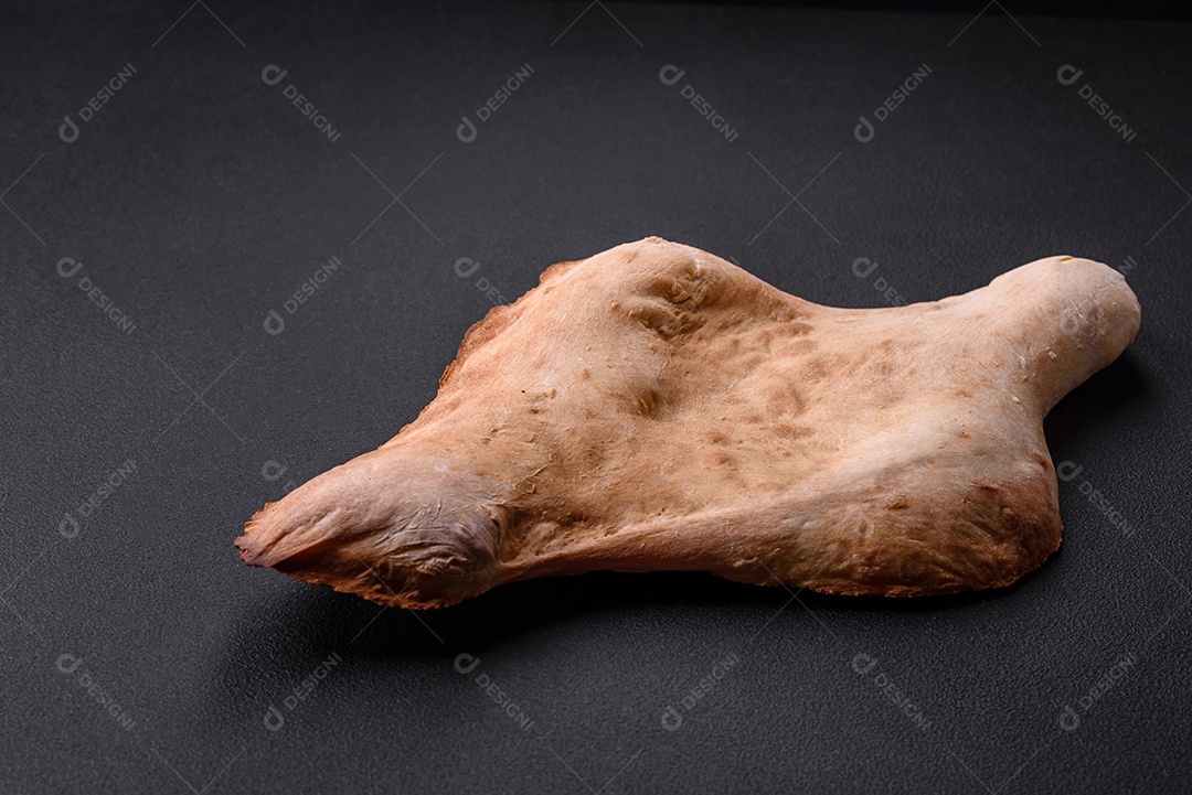 Delicioso pão georgiano fresco e crocante assado no forno sobre um fundo escuro de concreto