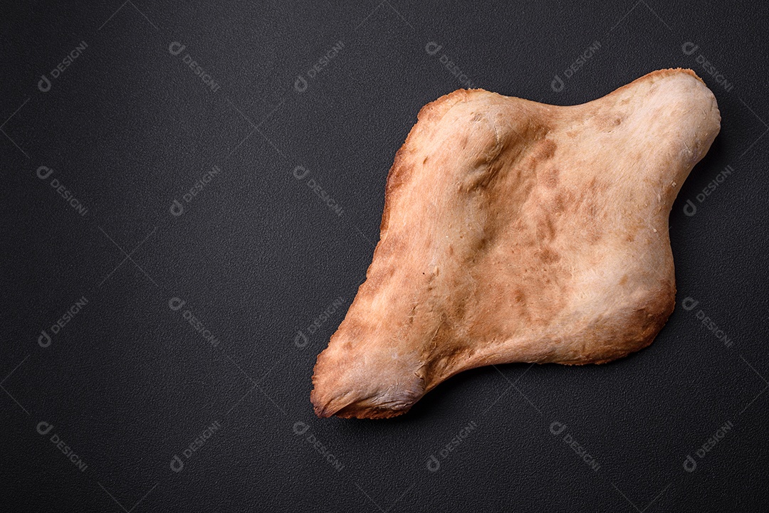Delicioso pão georgiano fresco e crocante assado no forno sobre um fundo escuro de concreto