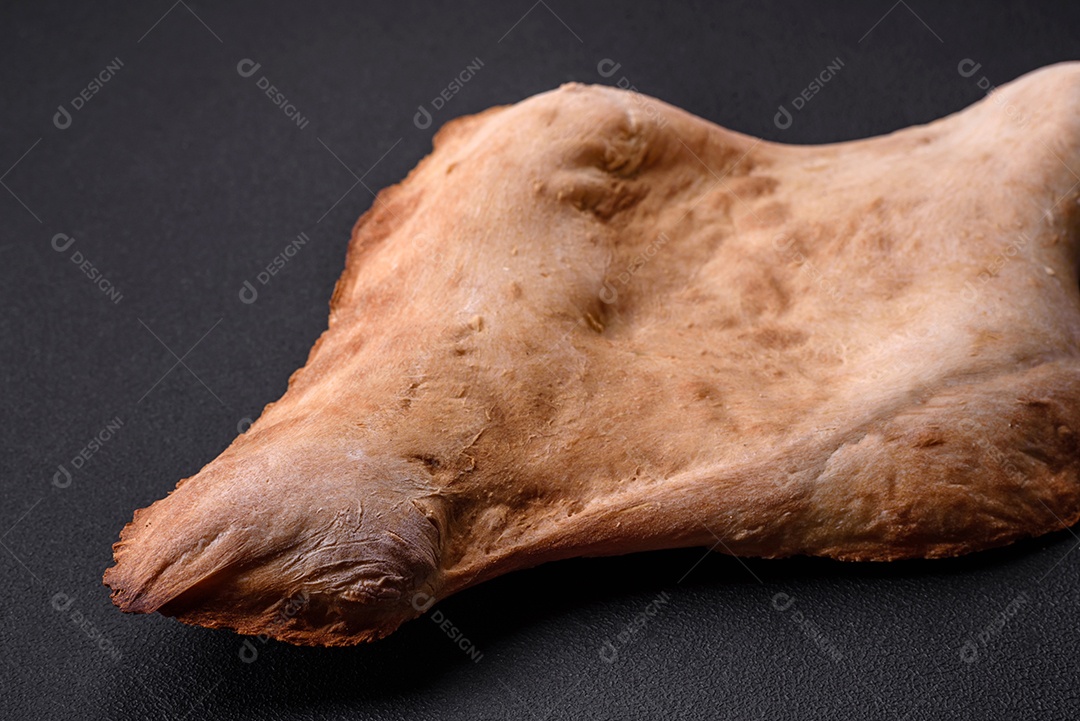 Delicioso pão georgiano fresco e crocante assado no forno sobre um fundo escuro de concreto