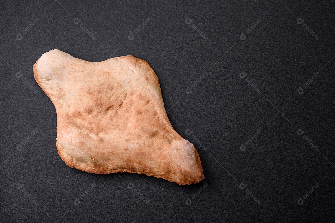 Delicioso pão georgiano fresco e crocante assado no forno sobre um fundo escuro de concreto