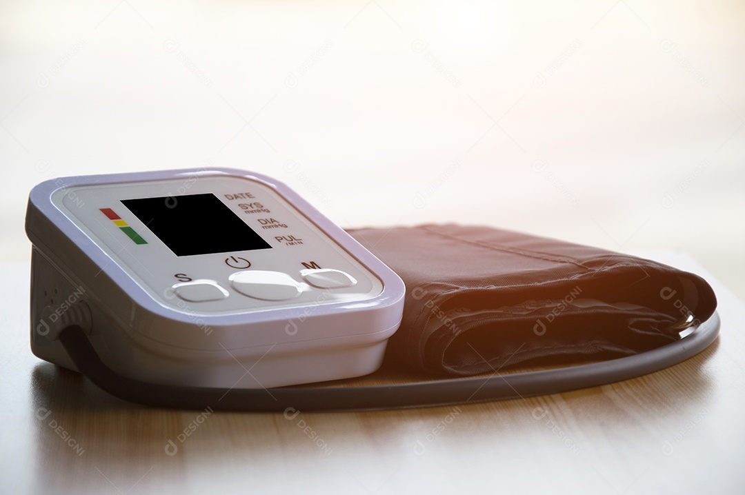 Monitor de pressão arterial colocado sobre uma mesa de madeira