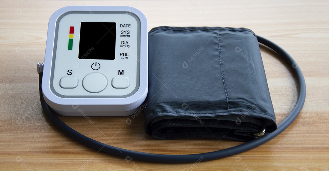 Monitor de pressão arterial colocado sobre uma mesa de madeira
