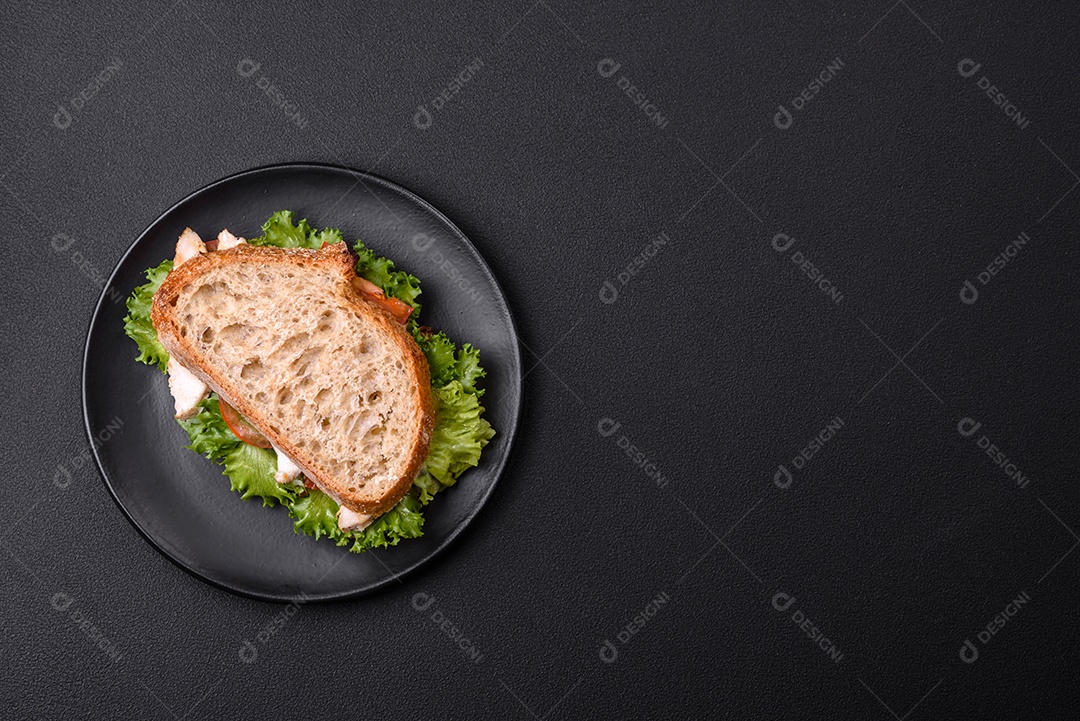 Sanduíche fresco e saboroso com salmão, abacate e sementes de gergelim e linho sobre um fundo escuro de concreto