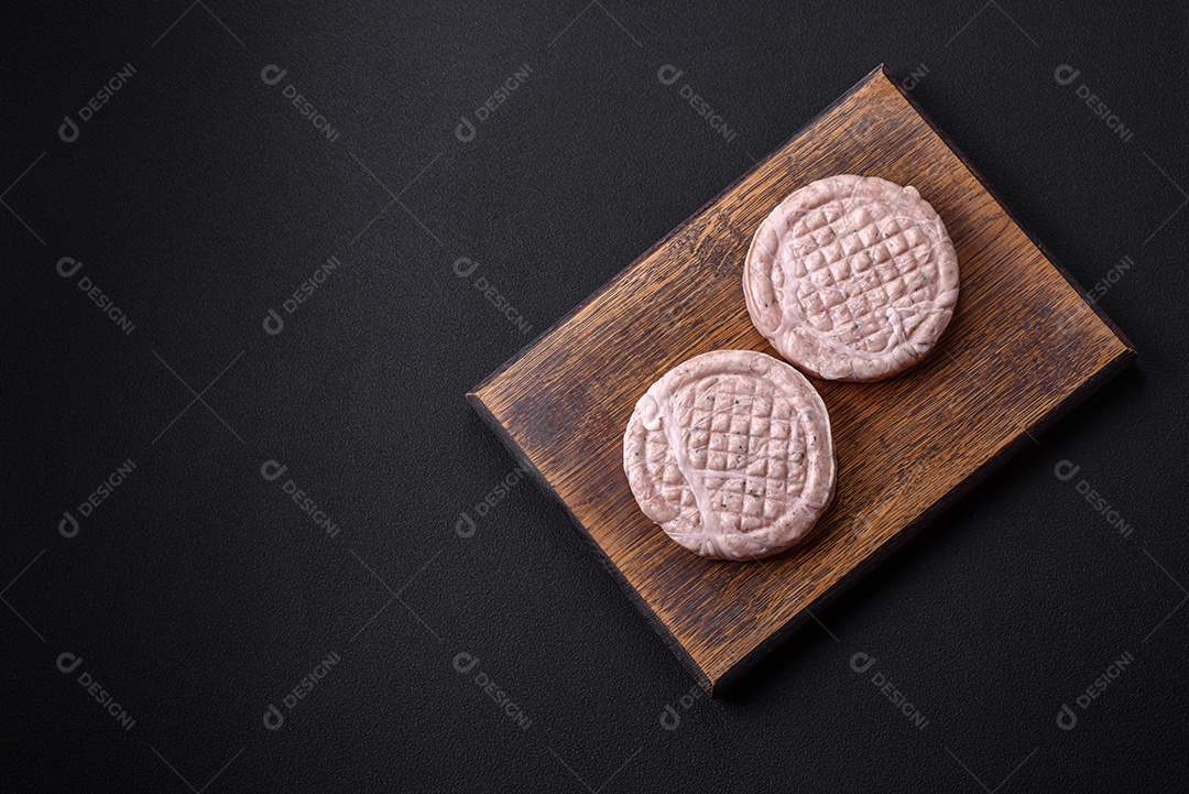 Almôndegas de carne crua com especiarias e ervas ou crepinette sobre um fundo escuro de concreto